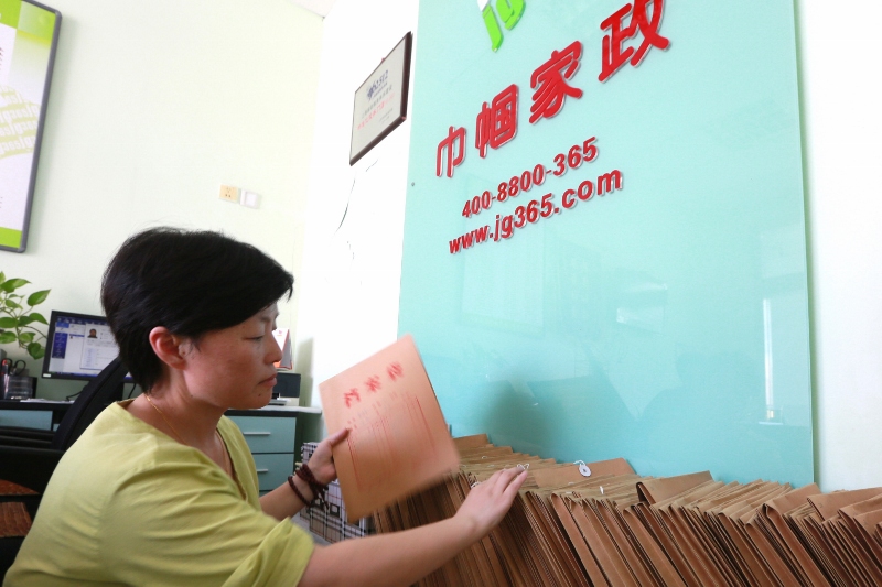 陈君正在整理家政人员材料 张灏摄 (800x533).jpg
